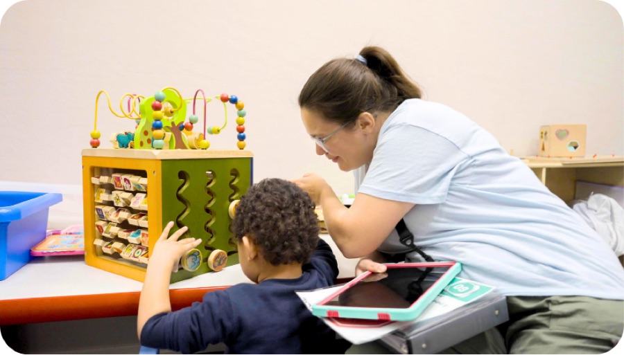 Therapist and child exploring an activity cube together
