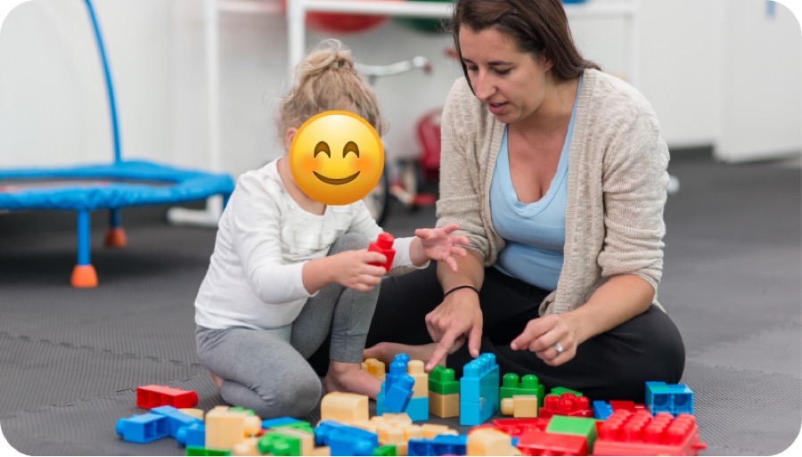Therapist and child building with blocks on the floor
